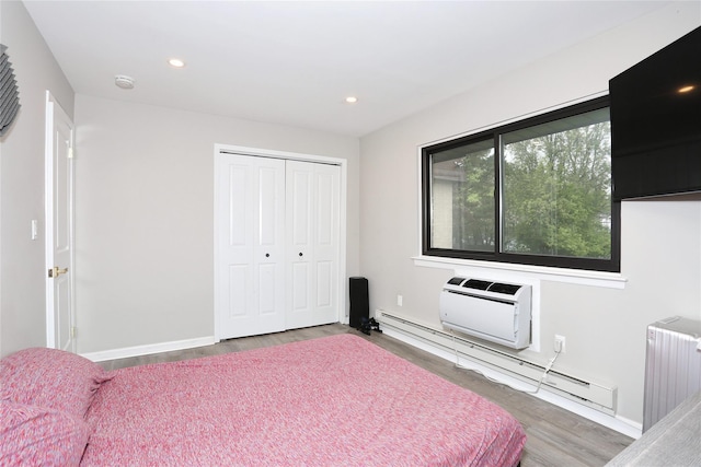 221 Richard Ct, Pomona, NY 10970 - bedroom with radiator, wood finished floors, a baseboard radiator, a closet, and a wall unit AC