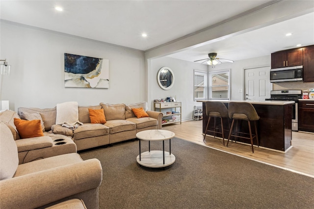 1343 E St, Elmont, NY 11003 - living room with light wood finished floors, ceiling fan, recessed lighting, ornamental molding, and baseboards