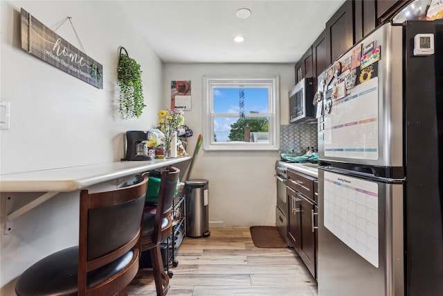 1343 E St, Elmont, NY 11003 - kitchen with appliances with stainless steel finishes, dark brown cabinets, light wood-style flooring, light countertops, and recessed lighting