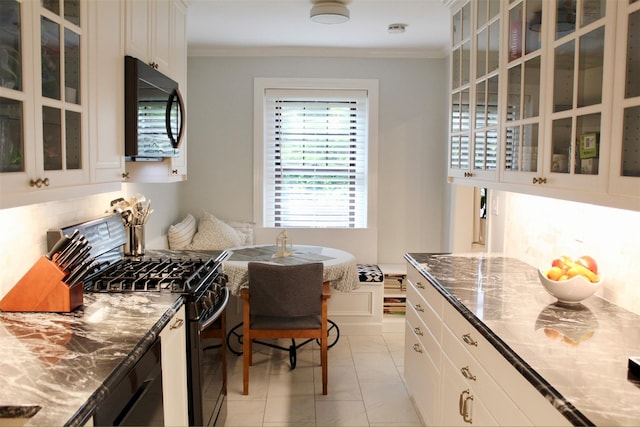 209 Garth Rd Unit 1K, Scarsdale, NY 10583 - kitchen with black appliances, crown molding, glass insert cabinets, dark stone countertops, and white cabinets