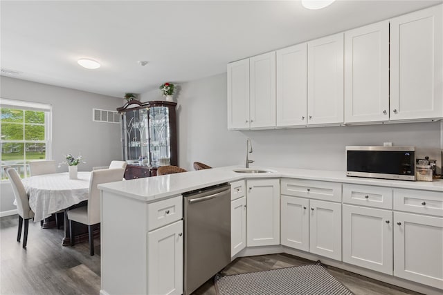 241 Fairview Cir, Middle Island, NY 11953 - kitchen featuring stainless steel appliances, dark wood-style floors, a sink, a peninsula, and white cabinets