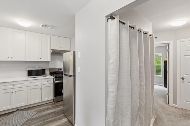 241 Fairview Cir, Middle Island, NY 11953 - kitchen featuring stainless steel appliances, white cabinetry, light countertops, and under cabinet range hood