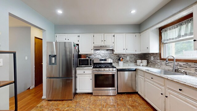 285 Riley Rd, New Windsor, NY 12553 - kitchen with stainless steel appliances, a sink, under cabinet range hood, backsplash, and white cabinets