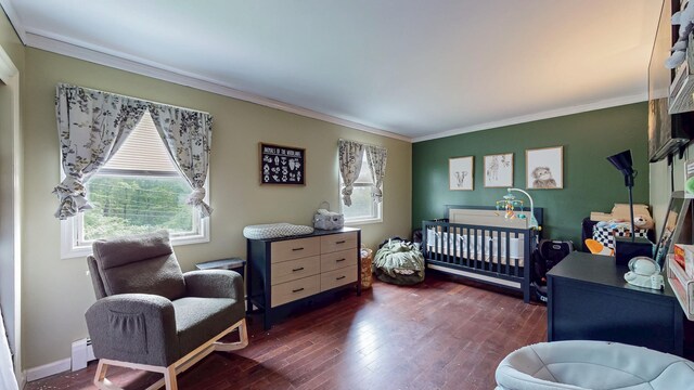 285 Riley Rd, New Windsor, NY 12553 - bedroom with crown molding, dark wood-style flooring, a crib, baseboards, and a baseboard radiator