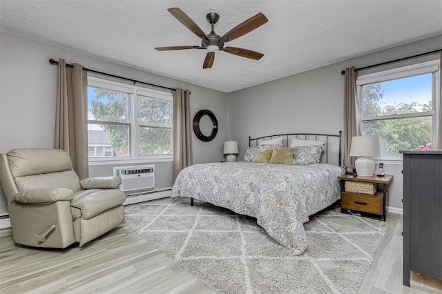 9 Danbury Ct Unit 1601, Suffern, NY 10901 - bedroom featuring a baseboard heating unit, wood finished floors, multiple windows, a textured ceiling, and a ceiling fan