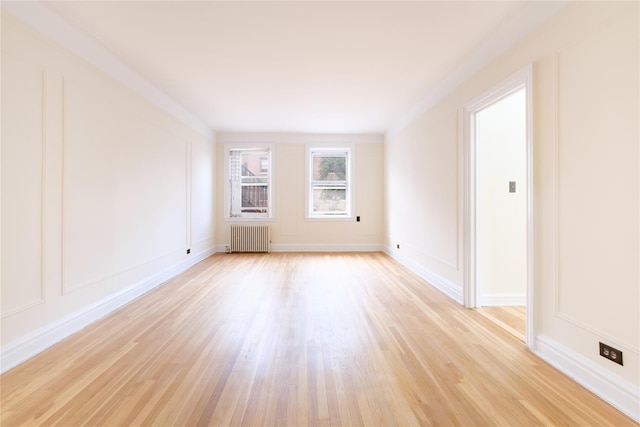 19 William St Unit 3G, Mount Vernon, NY 10552 - unfurnished room featuring radiator, light wood-style flooring, and a decorative wall