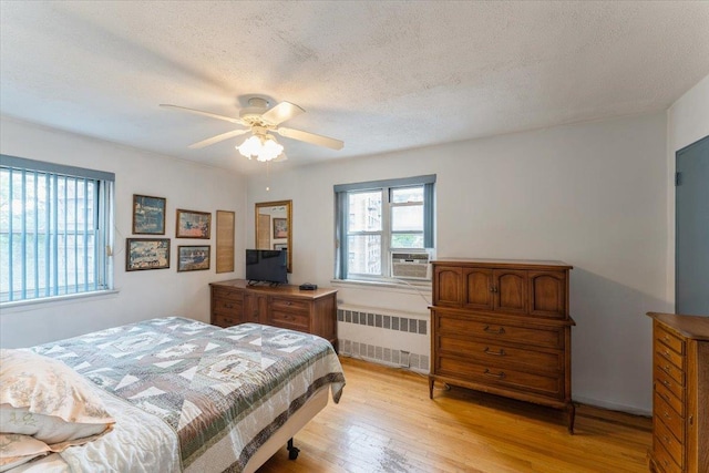 31-90 140th St Unit 3K, Flushing, NY 11354 - bedroom with radiator heating unit, light wood-style flooring, a textured ceiling, and ceiling fan
