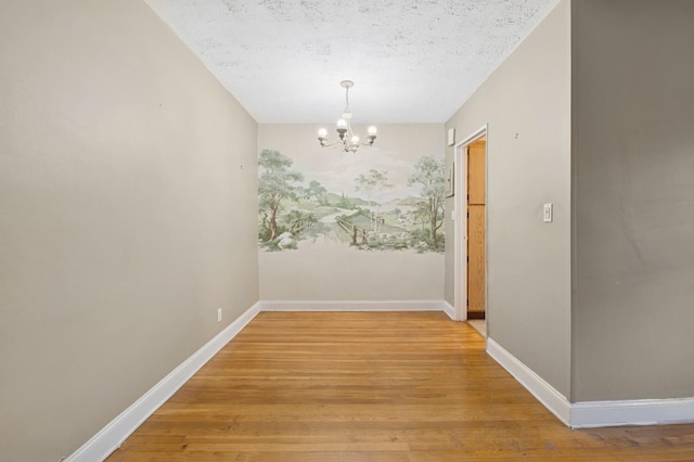199-07 21st Ave Unit 1-361, Whitestone, NY 11357 - unfurnished dining area with a chandelier, light wood finished floors, baseboards, and a textured ceiling