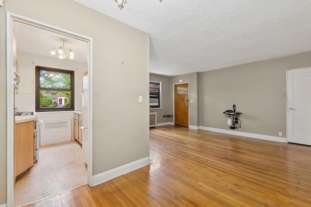 199-07 21st Ave Unit 1-361, Whitestone, NY 11357 - interior space with a textured ceiling, a chandelier, light wood-type flooring, and baseboards
