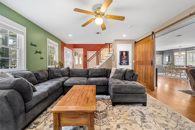21 Mile Rd, Suffern, NY 10901 - living room featuring a barn door, light wood-style floors, a ceiling fan, a chandelier, and stairs