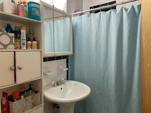 87-70 173rd St Unit 5E, Jamaica, NY 11432 - bathroom with a sink, backsplash, curtained shower, and tile walls