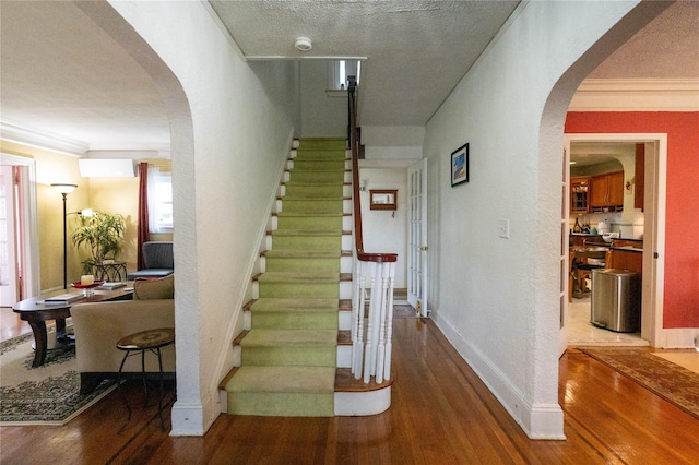42-32 204th St, Bayside, NY 11361 - stairs featuring arched walkways, wood finished floors, crown molding, baseboards, and a textured wall