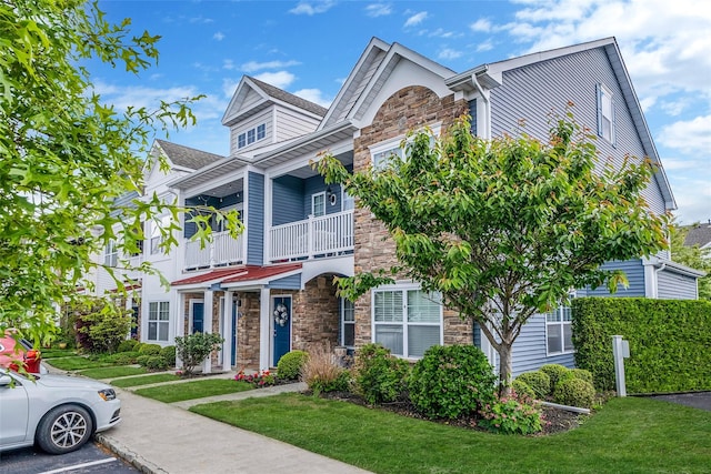 135 Rosebud Ct Unit 135, Patchogue, NY 11772 - townhome / multi-family property with stone siding, a front lawn, and a balcony