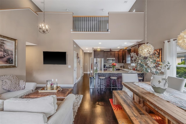 135 Rosebud Ct Unit 135, Patchogue, NY 11772 - living room with a towering ceiling, dark wood-style floors, baseboards, and a chandelier