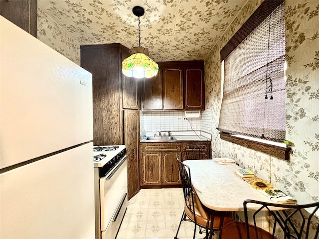 26-20 141st St Unit 1E, Flushing, NY 11354 - kitchen with white appliances, wallpapered walls, light flooring, a sink, and hanging light fixtures
