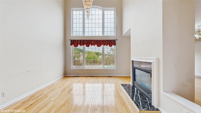 3 Caledonia Cir, Highland Mills, NY 10930 - unfurnished living room with wood finished floors, a premium fireplace, a high ceiling, and baseboards