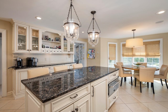 82 Woods Dr, East Hills, NY 11576 - kitchen featuring a warming drawer, light tile patterned floors, hanging light fixtures, a center island, and open shelves
