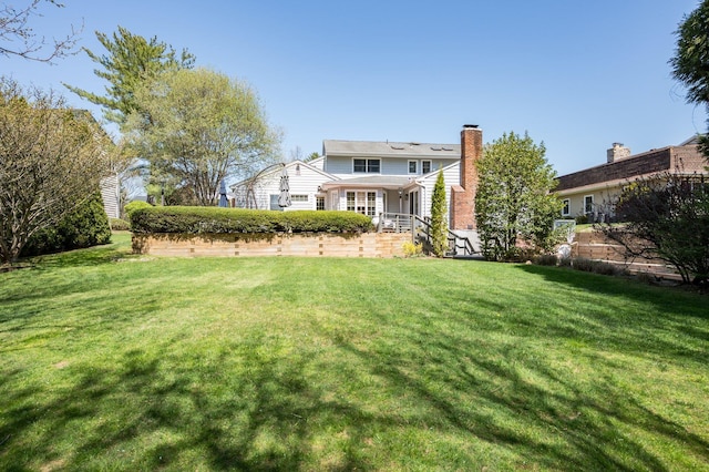 82 Woods Dr, East Hills, NY 11576 - rear view of house featuring a lawn and a chimney