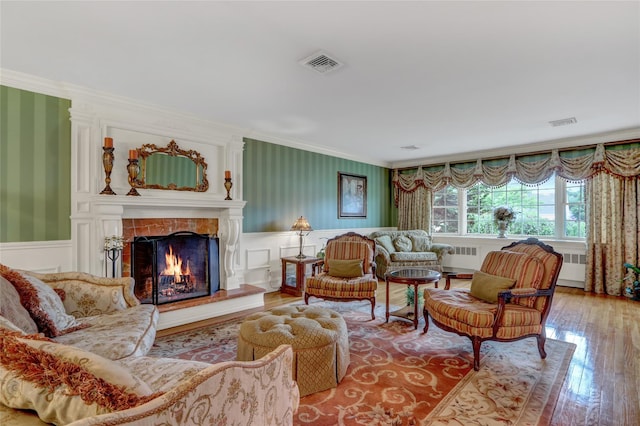100 Fairfax Rd, Massapequa, NY 11758 - living room featuring radiator heating unit, wallpapered walls, ornamental molding, hardwood / wood-style floors, and a wainscoted wall