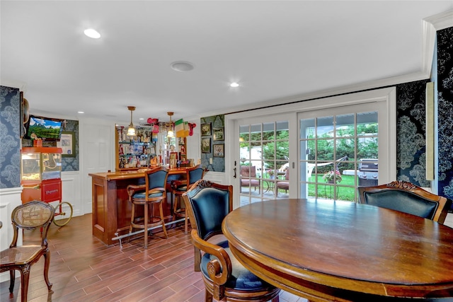 100 Fairfax Rd, Massapequa, NY 11758 - dining area with wallpapered walls, a decorative wall, a bar, crown molding, and a wainscoted wall