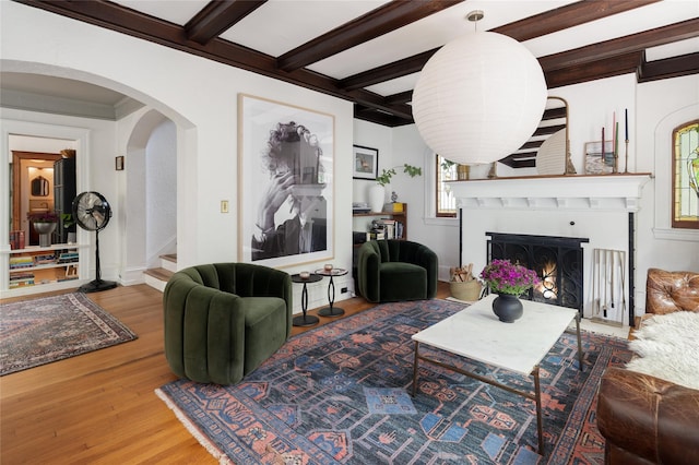 305 Park Hill Ave, Yonkers, NY 10705 - living area with wood finished floors, arched walkways, a lit fireplace, stairs, and beam ceiling