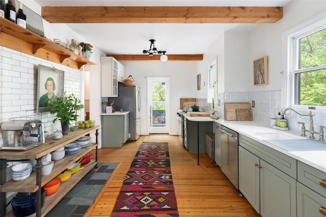 305 Park Hill Ave, Yonkers, NY 10705 - kitchen with stainless steel appliances, beamed ceiling, backsplash, light countertops, and light wood-style flooring
