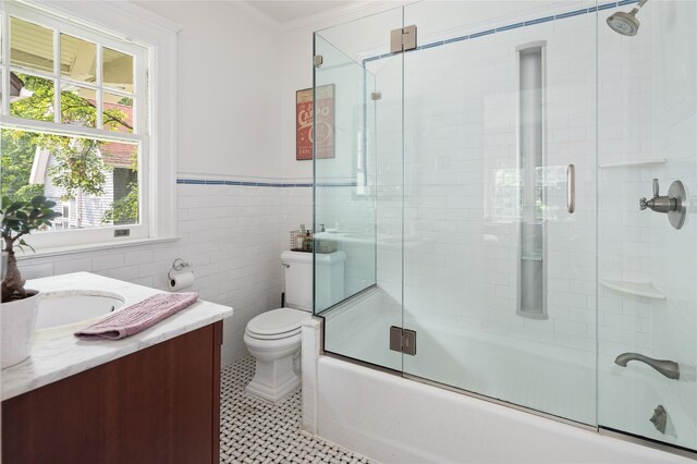 305 Park Hill Ave, Yonkers, NY 10705 - full bath featuring vanity, bath / shower combo with glass door, plenty of natural light, a wainscoted wall, and tile walls