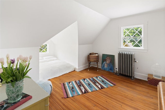 305 Park Hill Ave, Yonkers, NY 10705 - bedroom featuring radiator heating unit, multiple windows, lofted ceiling, and wood finished floors