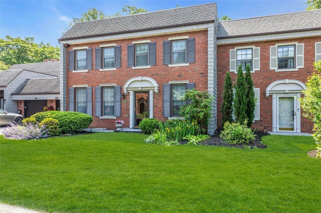 82 Harbour Ln, Bay Shore, NY 11706 - view of front facade featuring a front yard, brick siding, and roof with shingles