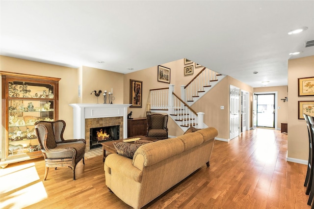 82 Harbour Ln, Bay Shore, NY 11706 - living room with a tile fireplace, stairway, wood finished floors, and recessed lighting