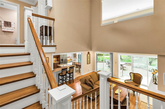 82 Harbour Ln, Bay Shore, NY 11706 - stairs with a towering ceiling, wood finished floors, and ornamental molding