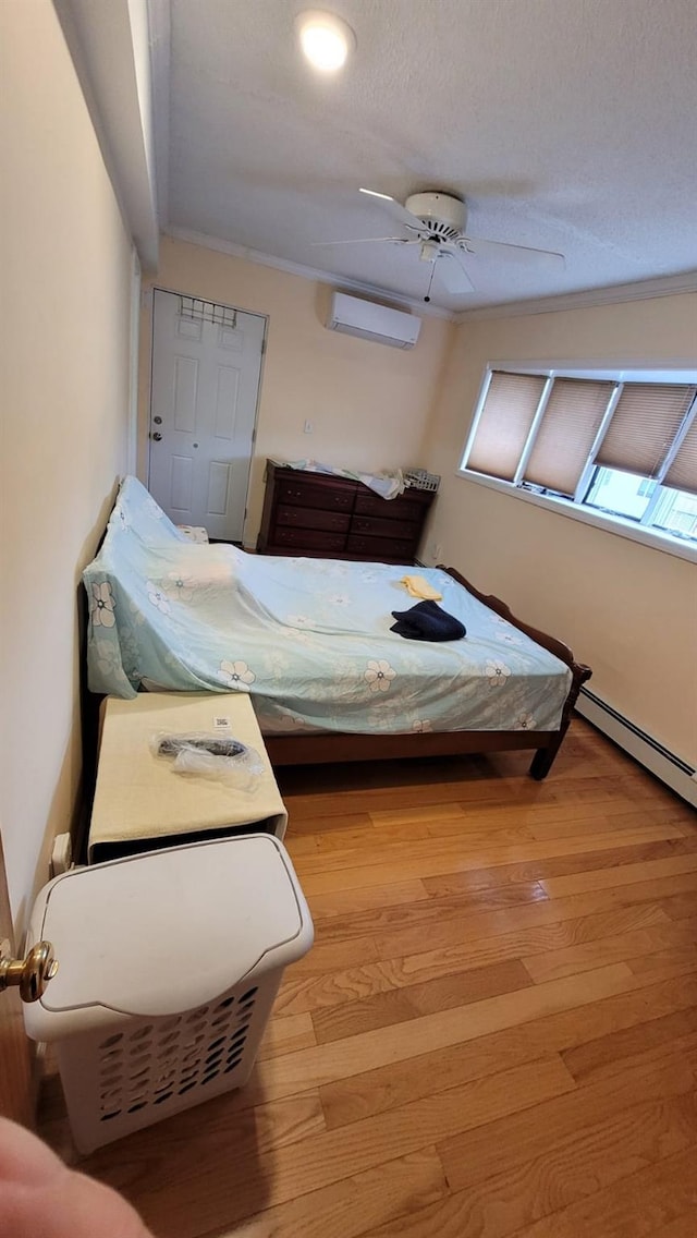 10 W 15th Rd, Broad Channel, NY 11693 - bedroom with a wall unit AC, wood finished floors, a baseboard heating unit, ceiling fan, and crown molding