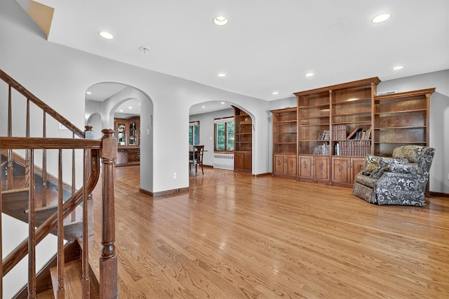 15 Dr Frank Rd, Spring Valley, NY 10977 - sitting room featuring radiator, arched walkways, light wood-style flooring, recessed lighting, and stairs