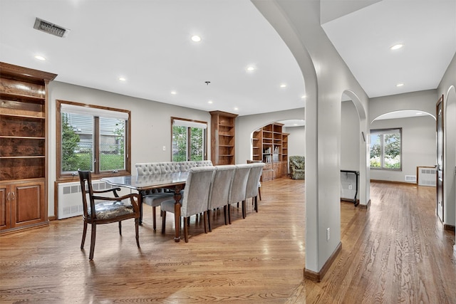 15 Dr Frank Rd, Spring Valley, NY 10977 - dining area with radiator heating unit, arched walkways, light wood-type flooring, recessed lighting, and built in features