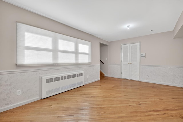 15 Dr Frank Rd, Spring Valley, NY 10977 - empty room featuring radiator, light wood-style flooring, stairway, and wainscoting