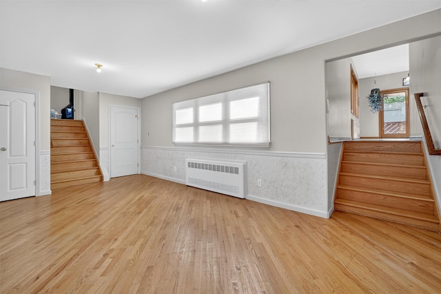 15 Dr Frank Rd, Spring Valley, NY 10977 - unfurnished living room with radiator heating unit, stairway, wood finished floors, and wainscoting