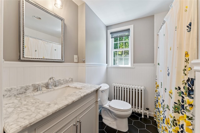 66 Riverview Rd, Irvington, NY 10533 - bathroom with radiator heating unit, a wainscoted wall, vanity, toilet, and tile patterned floors