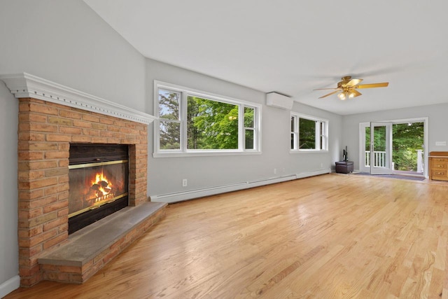 571 Farm To Market Rd, Brewster, NY 10509 - unfurnished living room with a wall unit AC, a baseboard heating unit, wood finished floors, a brick fireplace, and a ceiling fan