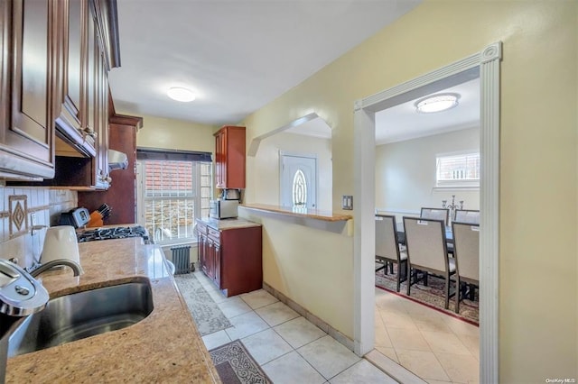 21-89 47th St, Long Island City, NY 11105 - kitchen featuring a sink, stainless steel gas range oven, radiator, light tile patterned floors, and baseboards