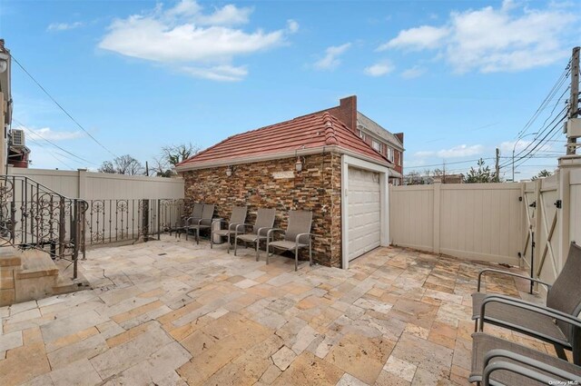 21-89 47th St, Long Island City, NY 11105 - fenced backyard featuring a garage, a gate, and a patio area