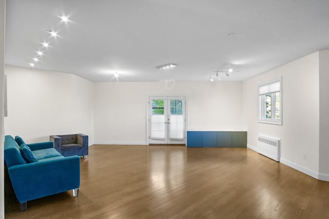 87 Horton Dr, Monsey, NY 10952 - sitting room with radiator heating unit, wood finished floors, baseboards, and french doors