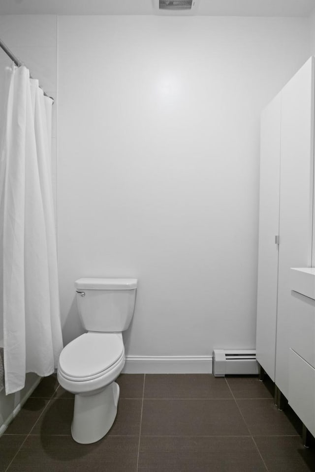 87 Horton Dr, Monsey, NY 10952 - bathroom with a baseboard heating unit, toilet, tile patterned flooring, and curtained shower