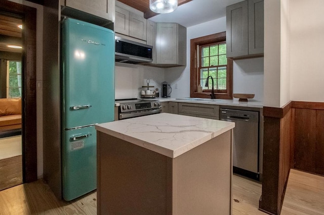 22 Mount Laurel Rd, Greenfield Park, NY 12435 - kitchen featuring appliances with stainless steel finishes, a sink, gray cabinetry, a kitchen island, and a wainscoted wall