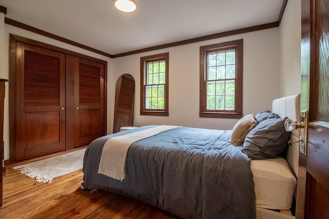 22 Mount Laurel Rd, Greenfield Park, NY 12435 - bedroom with light wood-type flooring, crown molding, a closet, and arched walkways