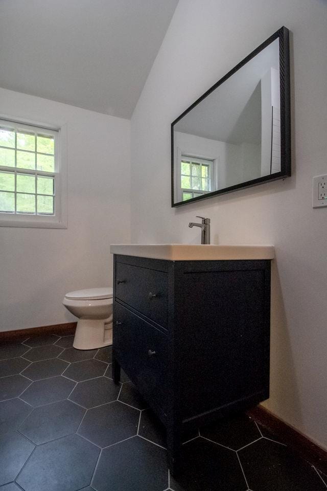 22 Mount Laurel Rd, Greenfield Park, NY 12435 - bathroom featuring vanity, toilet, vaulted ceiling, baseboards, and tile patterned flooring