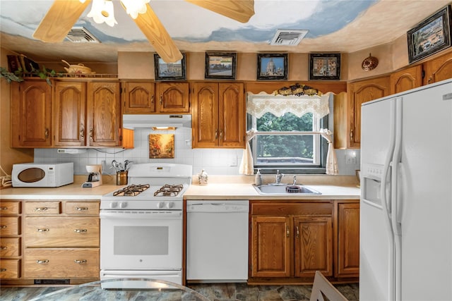 8 Cedar St, Tappan, NY 10983 - kitchen with white appliances, under cabinet range hood, brown cabinetry, and decorative backsplash