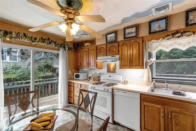 8 Cedar St, Tappan, NY 10983 - kitchen with white appliances, under cabinet range hood, brown cabinetry, backsplash, and light countertops