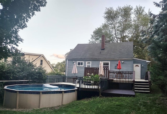8 Cedar St, Tappan, NY 10983 - rear view of property with a wooden deck, an outdoor pool, a chimney, and roof with shingles