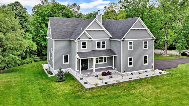 15 Somers Hills Rd, Carmel, NY 10512 - view of front of home with covered porch, a chimney, a front lawn, and a shingled roof