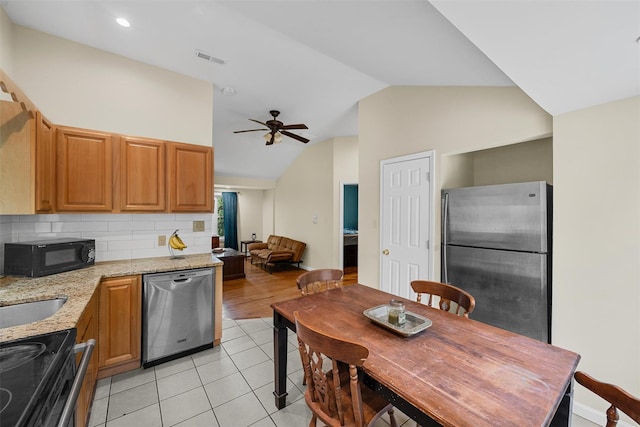22 Claremont Trl, Monroe, NY 10950 - kitchen with stainless steel appliances, lofted ceiling, ceiling fan, light tile patterned floors, and light stone countertops